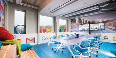 A Google Budapest iroda tárgyalóterme nyomtatott, vizet imitáló padlóval, hatalmas plasztikus Google felirattal az ablakokban, nagyméretű képernyőkkel és egyéb díszletekkel berendezve.
